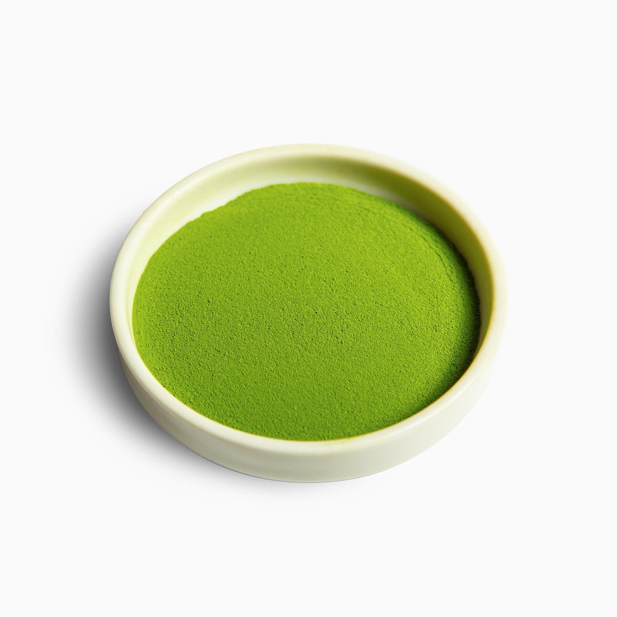 Green matcha powder in a shallow ceramic dish